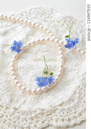 真珠のネックレスとレースと青い花 114947910