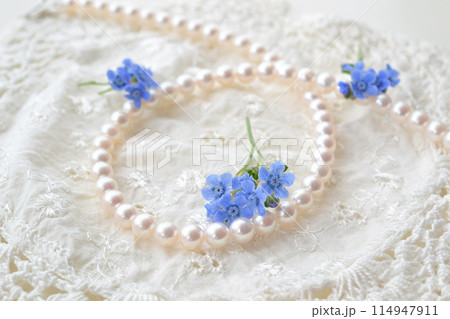 レースと真珠のネックレスと白いレースと青い花 114947911