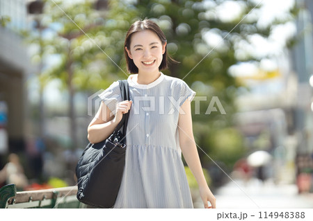 旅行で街中を歩く若い女性 旅行で街中を歩く若い女性 114948388