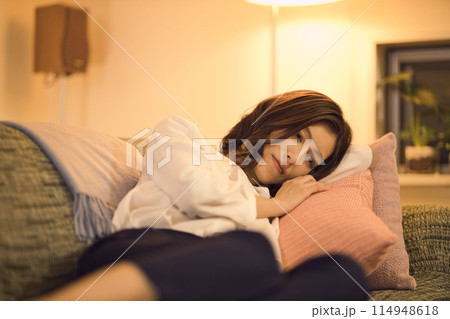 ジャケットを脱いでソファでくつろぐビジネスウーマン 　ナイトルーティーン　 114948618