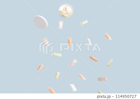 Different sachets of non-smoking tobacco product with different flavors are poured out of a plastic jar 114950727