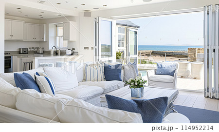 Interior of a living room with white walls, sofa and cushions. Sitting room in coastal cottage with sea view. Luxury lounge room 114952214