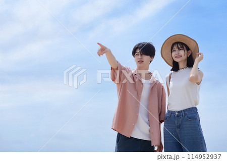 海辺を歩く若いカップル 114952937