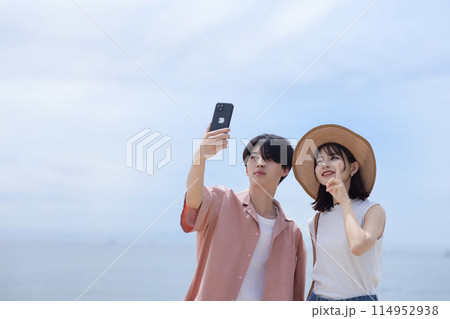 海辺を歩く若いカップル 114952938