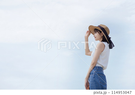 海辺を歩く若い女性 114953047