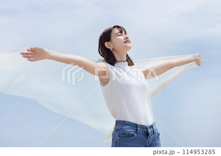 海辺で風を感じる若い女性 114953285
