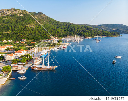 Scenic aerial view many yachts boats moored at Croatian bay harbor shore blue turquoise clear water at bright summer sunny day. Top above Mediterranean sea marina. Boat vessel charter service 114953971