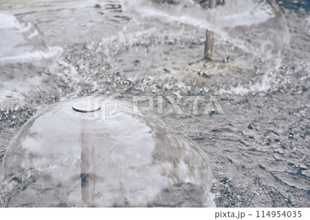A metal structure in the center of which transparent water forms a small fountain. The jets of water diverge to the sides, creating an effect of serenity. With space to copy. High quality photo A metal structure in the center of which transparent water forms a small fountain. The jets of water diverge to the sides, creating an effect of serenity. With space to copy. High quality photo 114954035