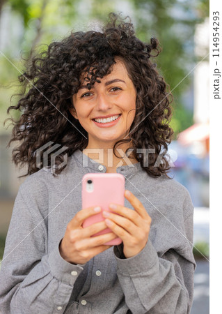 Caucasian young woman using smartphone typing text messages in social media application online Caucasian young woman using smartphone typing text messages in social media application online 114954293