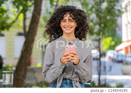 Caucasian young woman using smartphone typing text messages in social media application online 114954295