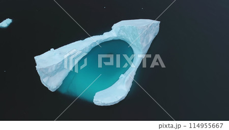 Iceberg floats in quiet Arctic ocean, ice formation crashed from melting glacier. Pure white ice and deep blue water. Ecology, melting ice, climate change global warming concept. Aerial drone panorama Iceberg floats in quiet Arctic ocean, ice formation crashed from melting glacier. Pure white ice and deep blue water. Ecology, melting ice, climate change global warming concept. Aerial drone panorama 114955667