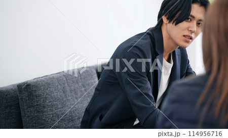 ソファに座って会話する男性 114956716