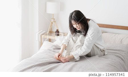 冷えた足を擦る女性 114957341