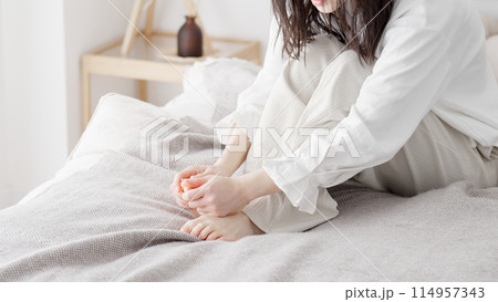 冷えた足を擦る女性 114957343