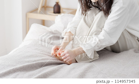 冷えた足を擦る女性 冷えた足を擦る女性 114957345