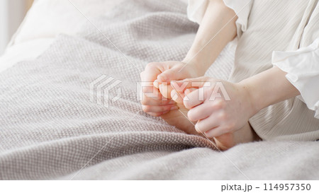 冷えた足を擦る女性 114957350