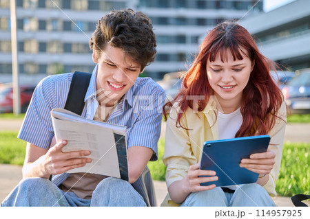 Teenage college students guy and girl talking, sitting outdoor 114957925