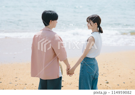 海辺を歩く若いカップル 114959082