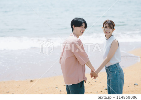 海辺を歩く若いカップル 114959086