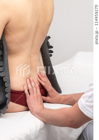Woman Receiving Osteopathic Treatment on Lower Back Woman Receiving Osteopathic Treatment on Lower Back 114959270