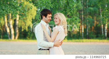 Portrait of beautiful happy smiling young couple in love together hugging in summer park Portrait of beautiful happy smiling young couple in love together hugging in summer park 114960725