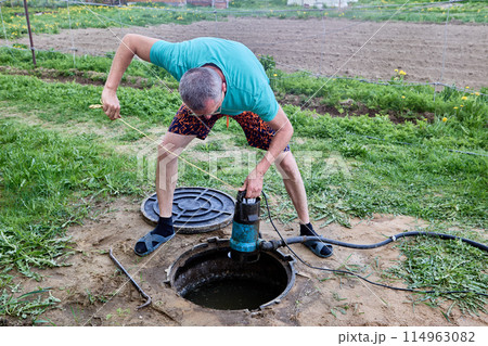 Pumping sewage from septic tank using submersible wastewater pump. Pumping sewage from septic tank using submersible wastewater pump. 114963082