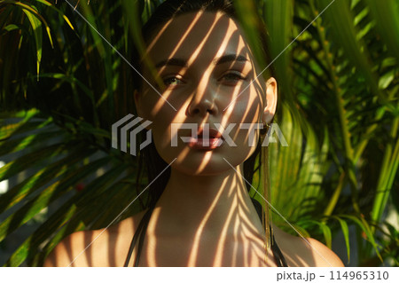 beautiful summer girl. young sexy woman in bikini under palm tree 114965310
