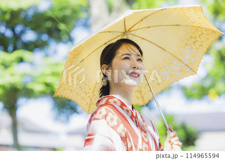 屋外を浴衣に日傘で歩く女性 屋外を浴衣に日傘で歩く女性 114965594