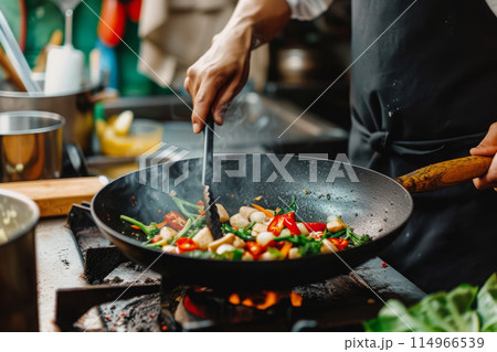 Man cooking vegetables in frying pan Man cooking vegetables in frying pan 114966539