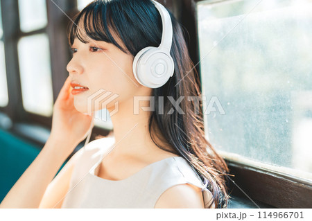 電車で音楽を聴く女性 114966701