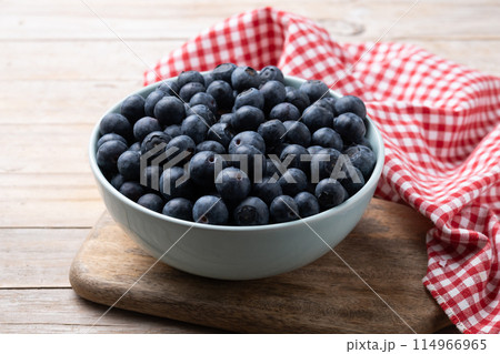 Blueberries in green bowl on wooden table 114966965