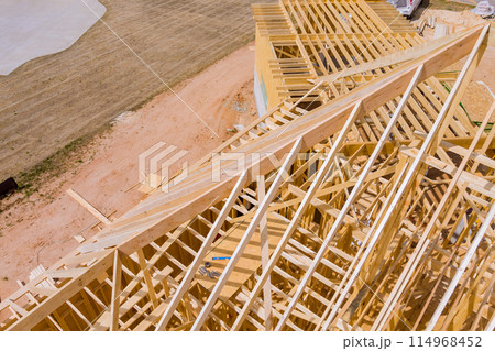 During construction of new home, unfinished frames wooden beams are seen 114968452