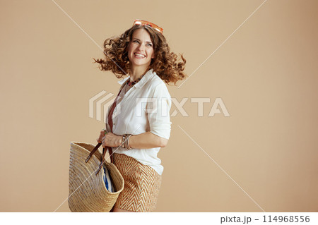 happy stylish woman in blouse and shorts on beige 114968556