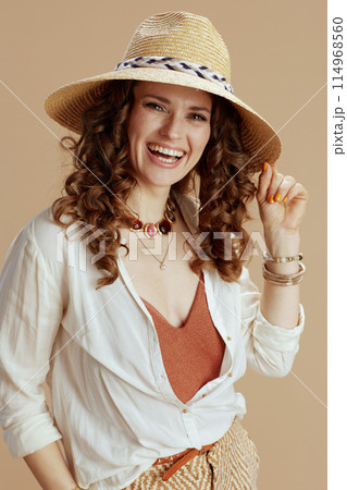 happy housewife in blouse and shorts against beige 114968560