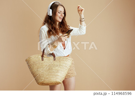 happy woman in blouse and shorts on beige happy woman in blouse and shorts on beige 114968596