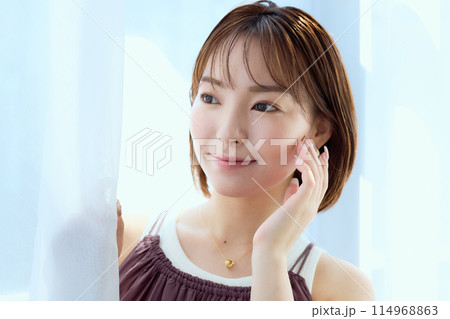 部屋の中でレースカーテン越しにくつろぐ女性 部屋の中でレースカーテン越しにくつろぐ女性 114968863