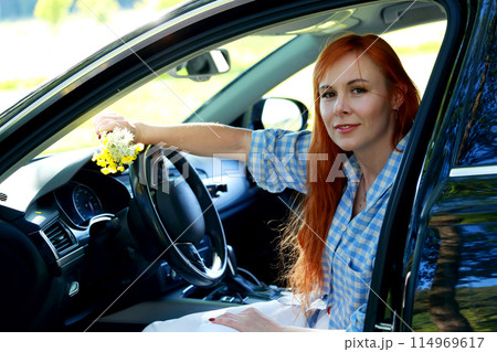A girl poses for the camera with her car in nature. Joy, happiness, serenity. A girl with a car in nature. A girl poses for the camera with her car in nature. Joy, happiness, serenity. A girl with a car in nature. 114969617