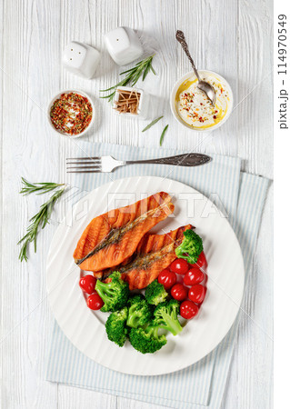 grilled salmon steaks with broccoli and tomatoes grilled salmon steaks with broccoli and tomatoes 114970549