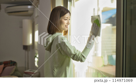 リビングの窓拭きをするミドル女性 114971069