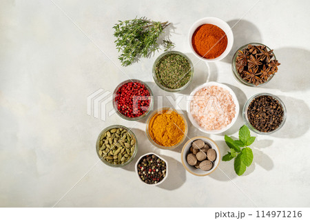 Spices and herbs in bowls, top view. Copy space 114971216