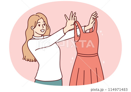 Woman examines beautiful evening dress choosing outfit for going to ball or festive party 114971483