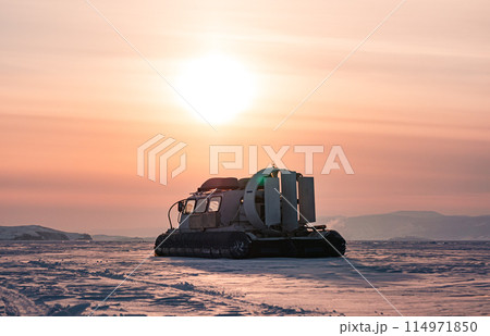 Hovercraft standing on snow covered ice surface of Lake Baikal at dusk. Hovercraft standing on snow covered ice surface of Lake Baikal at dusk. 114971850