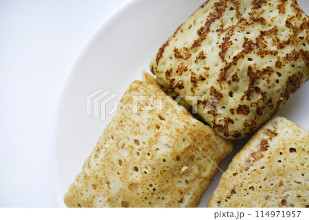 Pancakes with meat on a white plate. Delicious breakfast with meat filling. Pancakes with meat on a white plate. Delicious breakfast with meat filling. 114971957