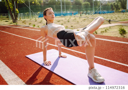 Young woman in sports outfit doing exercises outdoors in morning. Sport, Active life sports training 114972316