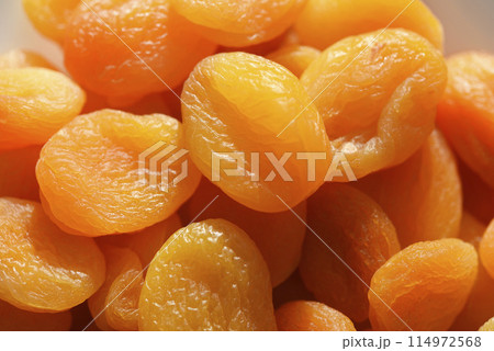 Dried fruits. Dried apricots. Dried apricots in close-up on a white plate. 114972568