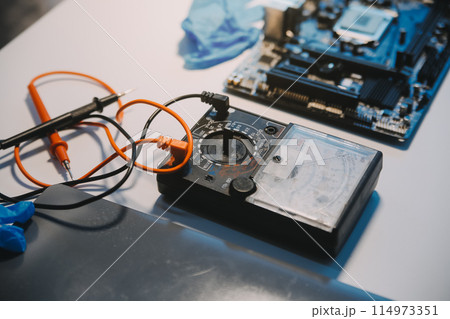Close up of Technician measuring voltage electronic circuit board television, Service after sale fix electric equipment within insurance. 114973351