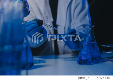 chemist,scientist hand dropping chemical liquid into test tube, science research and development concept chemist,scientist hand dropping chemical liquid into test tube, science research and development concept 114973410