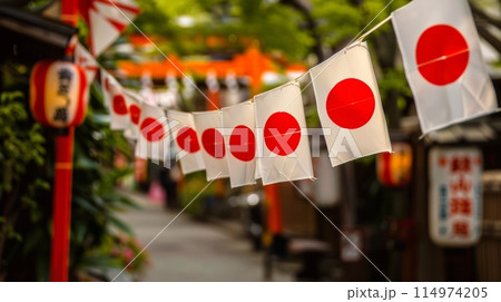 Japanese flag banners displayed with pride alongside traditional red circle lanterns in a serene alley, celebrating Japans rich cultural heritage. 114974205