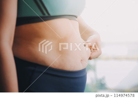 fat woman, fat belly, chubby, obese woman hand holding excessive belly fat with measure tape, woman diet lifestyle concept fat woman, fat belly, chubby, obese woman hand holding excessive belly fat with measure tape, woman diet lifestyle concept 114974578
