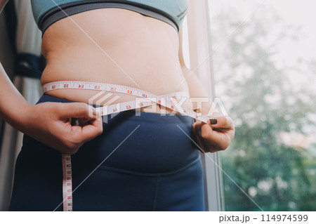 fat woman, fat belly, chubby, obese woman hand holding excessive belly fat with measure tape, woman diet lifestyle concept fat woman, fat belly, chubby, obese woman hand holding excessive belly fat with measure tape, woman diet lifestyle concept 114974599